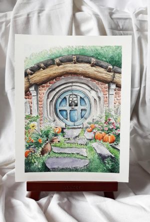 Aquarelle originale sur chevalet d'une façade de maison de Hobbit de la Comté avec sa porte ronde ©Ysae illustrations