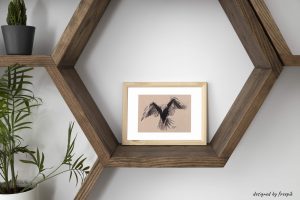 Décoration d'intérieur avec un cadre dans lequel se trouve une encre représentant un corbeau en plein vol