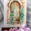 Dessin original réalisé à l'encre et à l'aquarelle, présenté sur chevalet, représentant une petite porte cachée derrière des roses trémières @Ysae illustrations