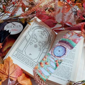 Marque-page "La Comté en automne présenté en situation dans un exemplaire du Signeur des Anneaux, avec une décoration automnale @ Ysae illustrations