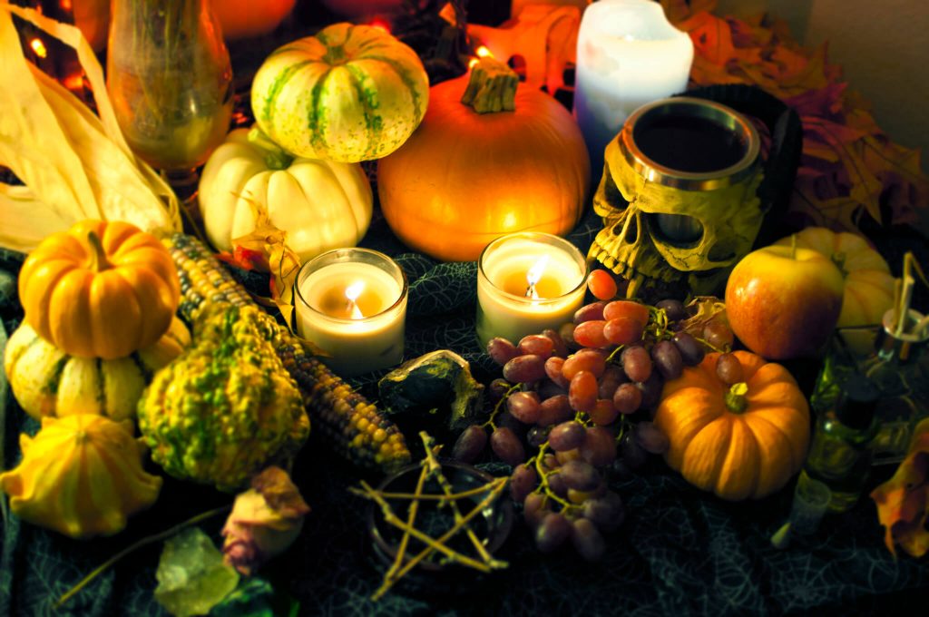 Photographie d'un autel pour la fête de Mabon avec des bougies, des fruits, des légumes et des signes ésotériques @ Amy Whelan