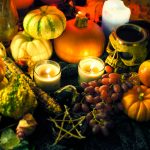 Photographie d'un autel pour la fête de Mabon avec des bougies, des fruits, des légumes et des signes ésotériques @ Amy Whelan
