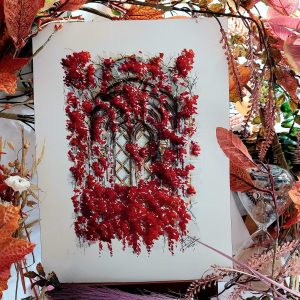 Dessin original à l'encre et à l'aquarelle présenté sur chevalet représentant une fenêtre médiévale cachée derrière des amas de feuilles rouges ©Ysae illustrations