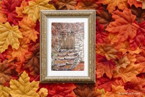 Impression laser d'une aquarelle originale présentée dans un cadre et représentant un bâtiment en pierre avec une vieille porte en bois et des feuilles mortes au sol @Ysae illustrations
