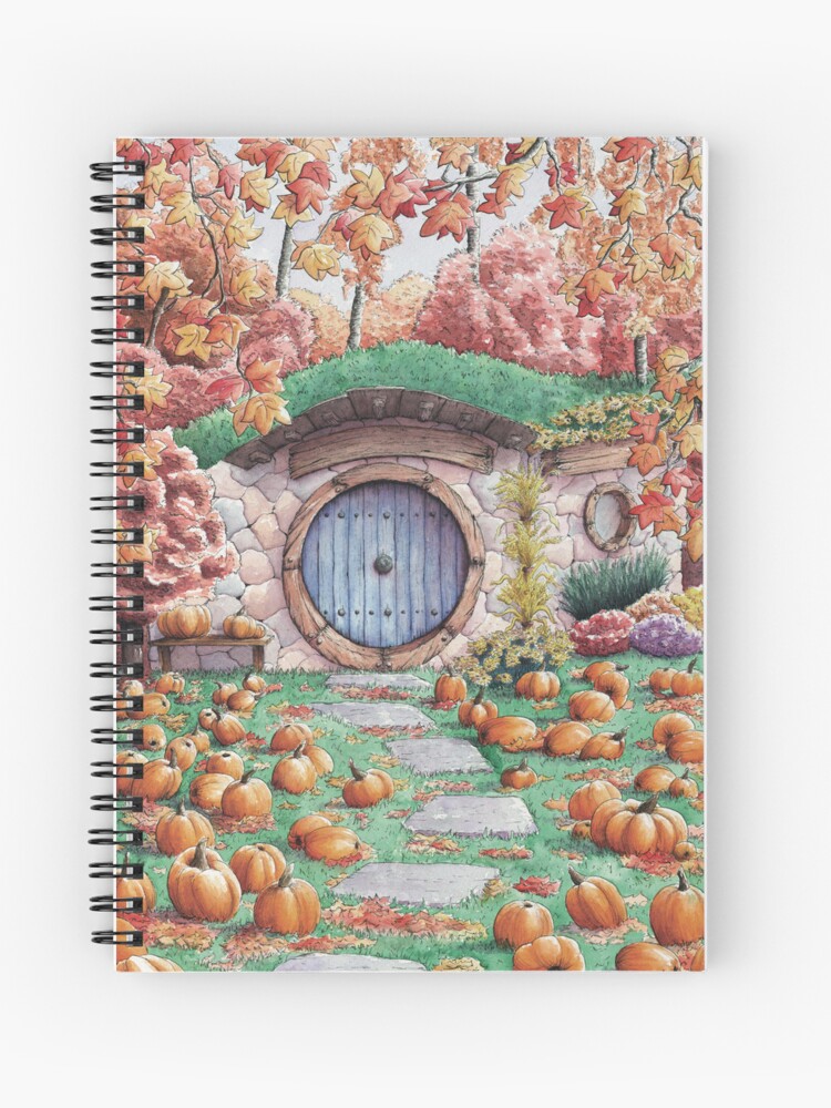 Carnet à spirales dont la couverture est un dessin à l'aquarelle représentant une maison de hobbit du Seigneur des anneaux avec sa porte ronde, en automne, avec des citrouilles plein le jardin pour Halloween ©Ysae illustrations