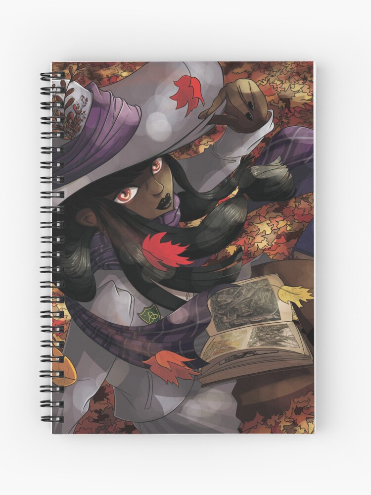 Carnet à spirales dont la couverture est un dessin numérique représentant une étudiante en sorcellerie qui regarde un livre de gravures anciennes, assises dans les feuilles morts de l'automne ©Ysae illustrations