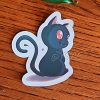 Sticker représentant un chat noir mignon avec des yeux rouges et des petites dents de vampire @Ysae illustrations