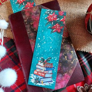 Marque-page illustré d'une pile de livre de Noël présenté sur un livre relié @Ysae illustrations