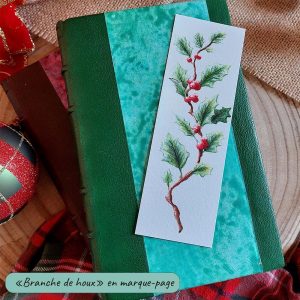 Marque-page illustré d'une branche de houx à l'aquarelle présenté sur un livre relié @Ysae illustrations
