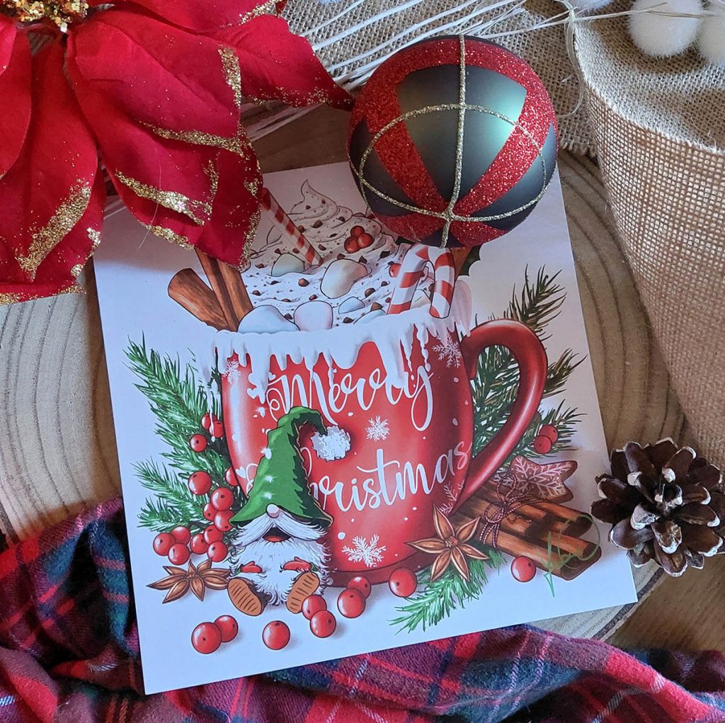 Carte postale représentant un mug plein de chocolat chaud, crène et marshmallows présentée entouré d'éléments de Noël @Ysae illustrations